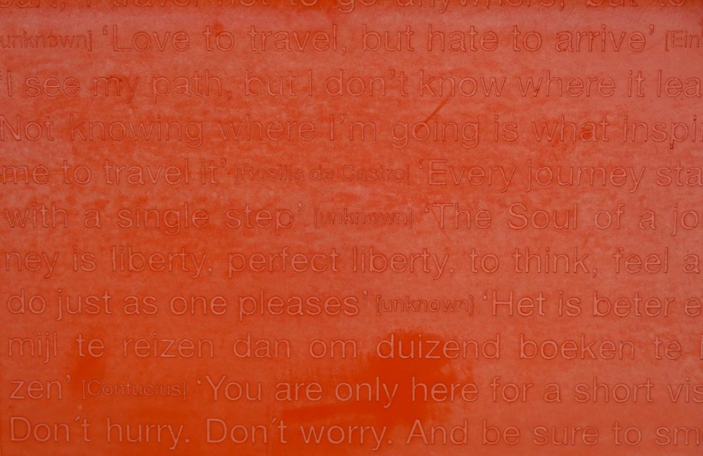 close up of a red surface with engraved quotes of rosalia de castro