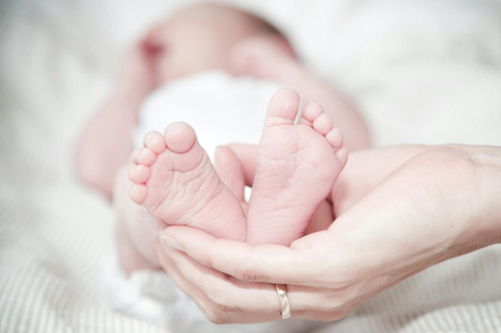 close up of hands holding baby feet