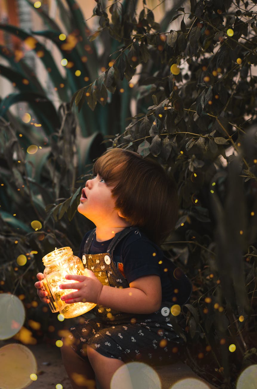 child holding clear glass jar with yellow light